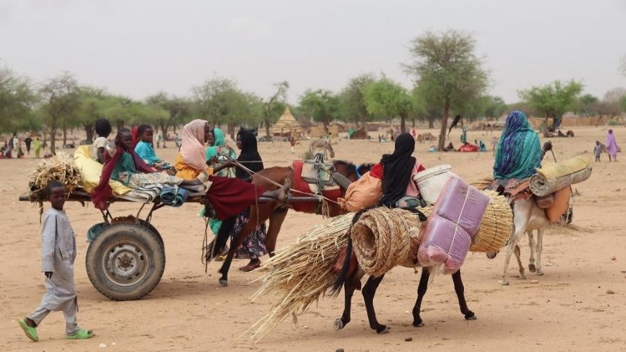 Refugiados sudaneses cruzam a fronteira entre o Sudão e o Chade para fugir do conflito entre Exército e paramilitares