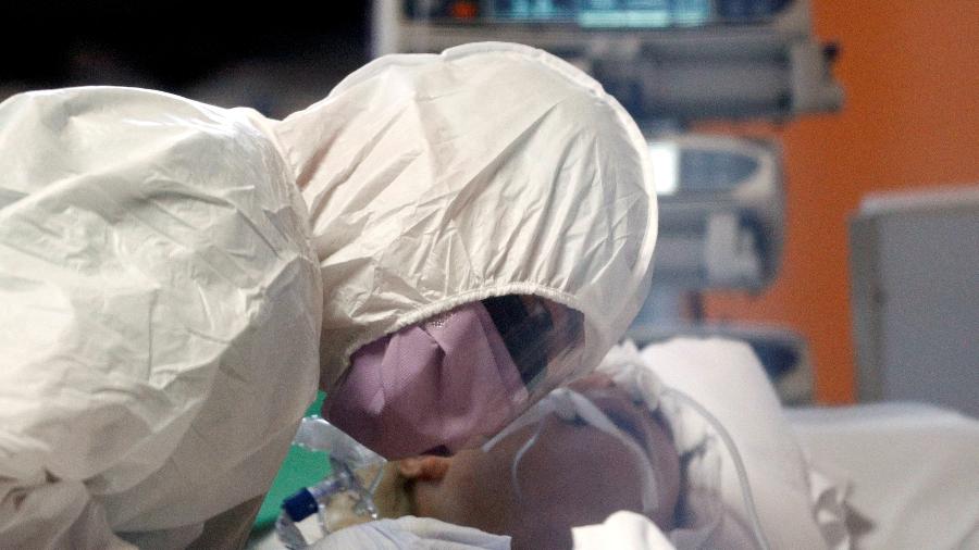Profissional médico com roupa de proteção atende paciente do novo coronavírus em hospital de Roma (Itália) - GUGLIELMO MANGIAPANE
