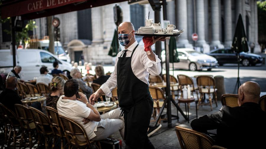 Um garçom trabalha no terraço do Cafe de Flore em Paris; cafés e restaurantes reabriram hoje na França - Martin BUREAU / AFP