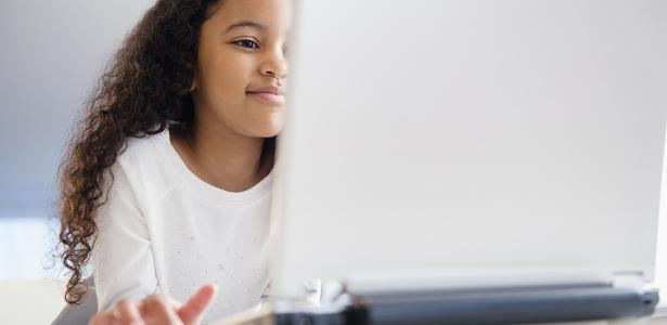 Menina negra usa computador para estudar