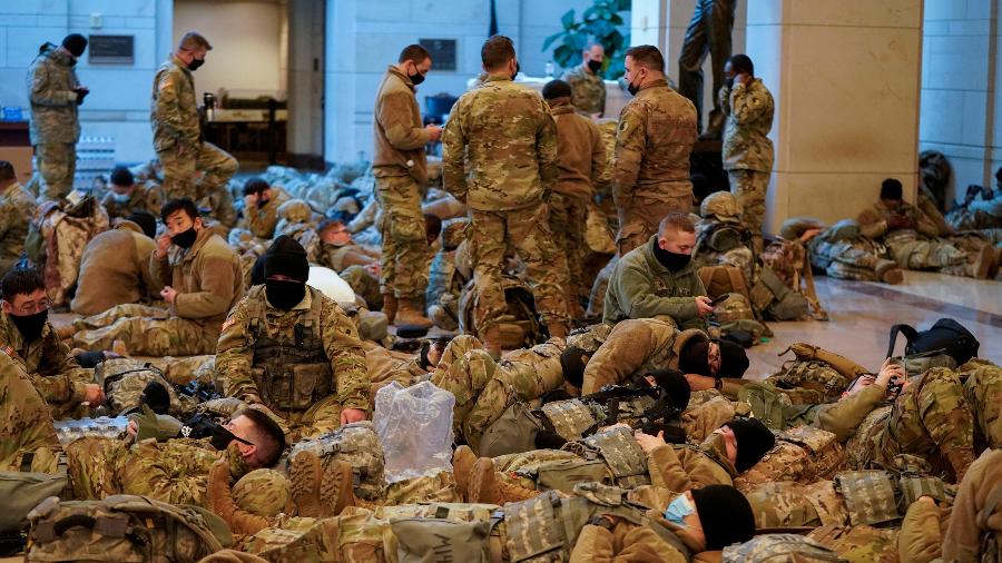 Membros da Guarda Nacional são vistos reunidos e descansando antes do início do debate na Câmara sobre impeachment do presidente Donald Trump no Capitólio - Joshua Roberts/Reuters