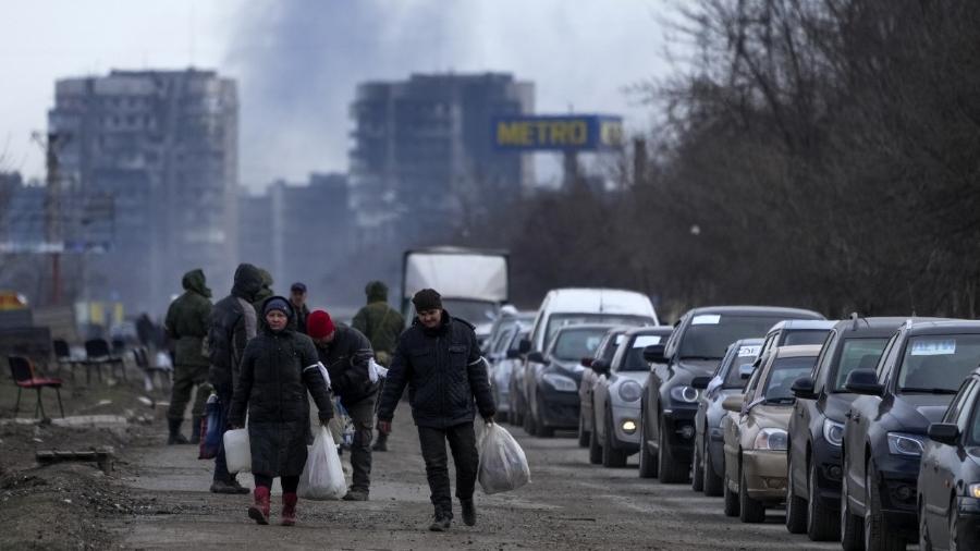 20.03.22 - Moradores deixam a cidade de Maripuol, no sudeste da Ucrânia, após intenso bombardeio russo - Stringer/Anadolu Agency