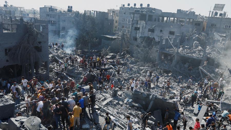 Palestinos procuram por sobreviventes em casas destruídas por ataque israelense em Khan Younis, sul da Faixa de Gaza