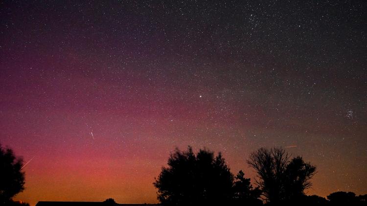 Imagem de longa exposição mostra a aurora boreal iluminando o céu no leste da Alemanha, durante a chuva anual de meteoros Perseidas