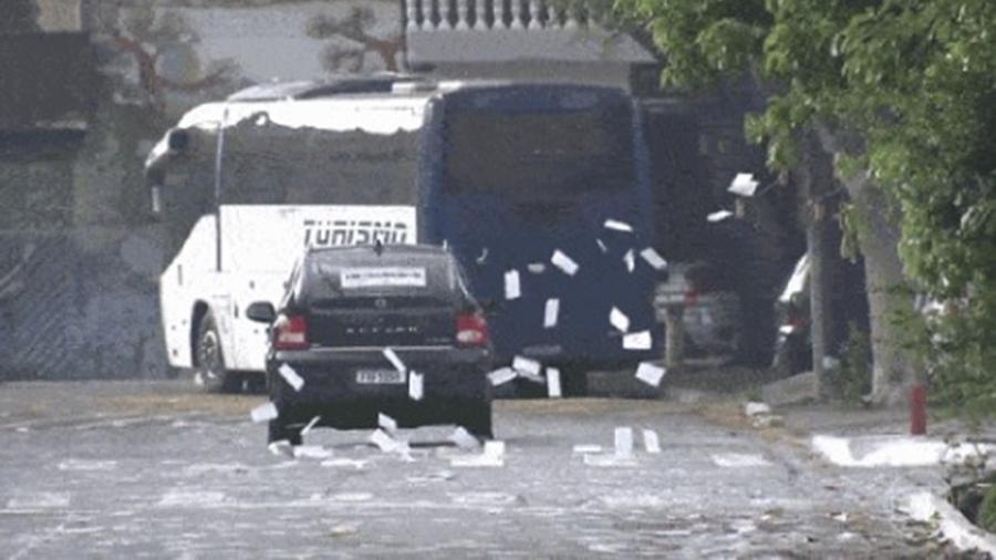 Pessoas de dentro de carro são flagradas espalhando "santinhos" em São Paulo - Reprodução/TV Globo