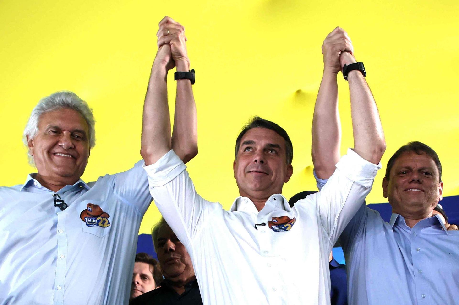 À esquerda, Ronaldo Caiado (PSD) sela seu apoio no segundo turno à candidatura de Flávio Bolsonaro (PL), no centro, ao lado do governador reeleito de São Paulo Tarcisio de Freitas (Republicanos), aliado da família Bolsonaro - undefined