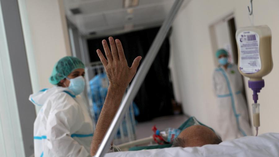 Paciente em recuperação da covid-19 acena quando é levado para um quarto de hospital regular após passar mais de cinquenta dias na unidade de terapia intensiva (UTI) do hospital da Universidade Infanta Sofia em Madri, Espanha - SUSANA VERA/REUTERS