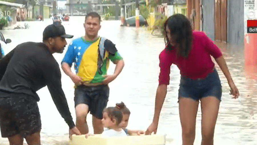 2.abr.2021 - Crianças são colocadas em caixa de isopor para fugir de enchente em Belford Roxo (RJ) - Reprodução/Globonews