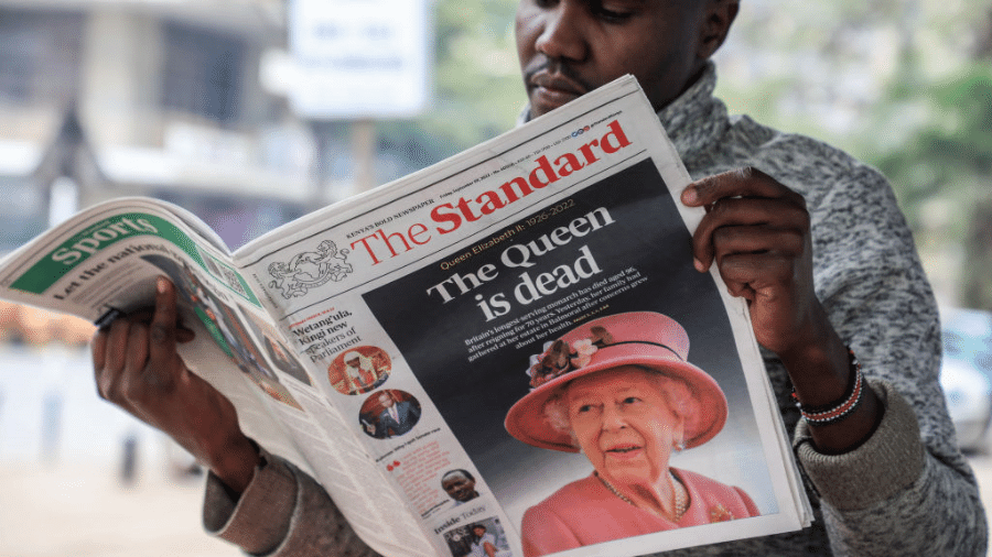 Homem lê jornal em Nairóbi, no Quênia, com manchete sobre a morte da rainha - Getty Images
