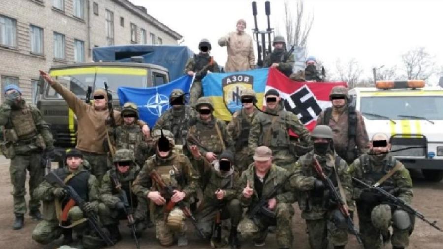 Acima, uma foto de 2016 do Batalhão Azov, que esteve em todos os governos desde 2014, inclusive no de Zelensky. É um dos mais poderosos grupos neonazistas do mundo e certamente o mais bem armado. Hoje, é um dos pilares da resistência. O Facebook cortava mensagens elogiando o grupo. Agora liberou! Vejam ali: as bandeiras da Otan e da milícia e a suástica - Reprodução