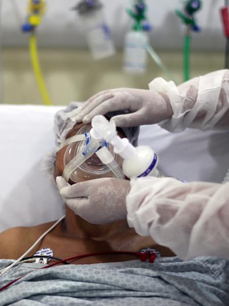Fisioterapeuta ajusta máscara de oxigênio em paciente com covid-19 em hospital de São Paulo - Amanda Perobelli/Reuters