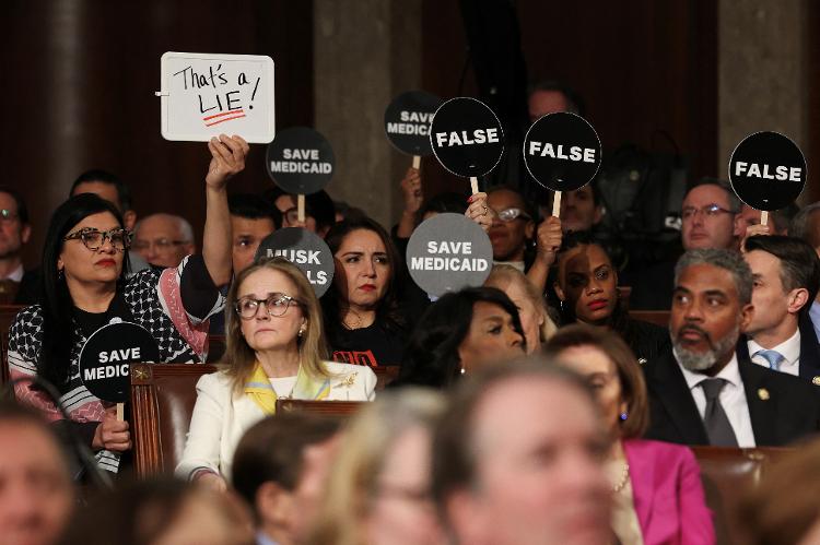 Congresssistas democratas usam placas com mensagens de protesto durante primeiro discurso do segundo mandato do presidente republicano Donald Trump em sessão conjunta no Capitólio Congresssistas democratas usam placas com mensagens de protesto durante primeiro discurso do segundo mandato do presidente republicano Donald Trump em sessão conjunta no Capitólio