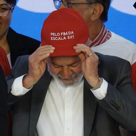 15.abr.2026 - O presidente Lula, durante encontro com centrais sindicais, veste boné pelo fim da escala 6x1