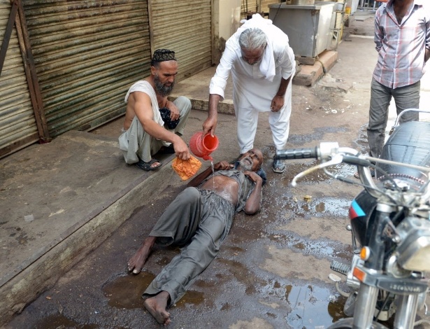 Médico atende vítima de insolação em rua de Karachi, no Paquistão - Rizwan Tabassum/AFP
