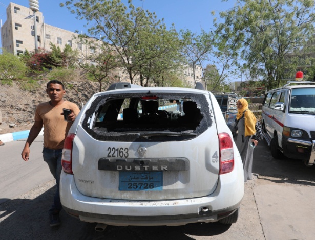 Jornalista verifica danos em veículo da Cruz Vermelha, após ataque que deixou uma pessoa morta em Taiz - Stringer/Reuters