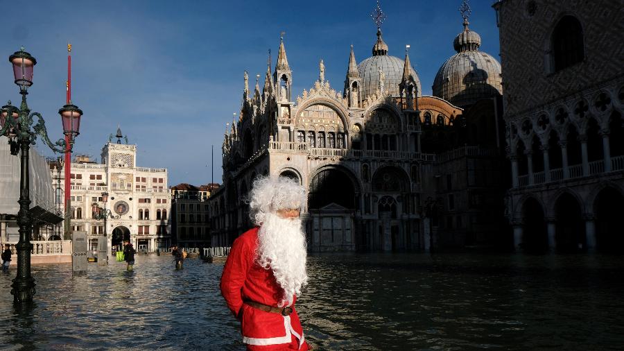 Homem vestido de Papai Noel caminha por trecho alagado de Veneza (Itália), na praça São Marcos - Manuel Silvestri/Reuters