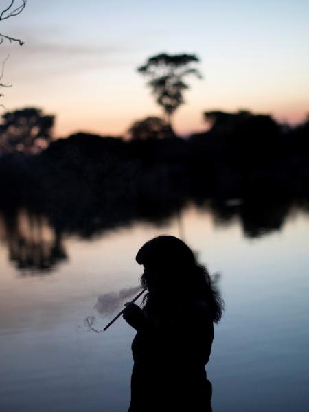 Mapulu, uma mulher kamayura, fuma ervas em ritual de pesca durante o Kuarup em homenagem à memória do cacique Aritana, no Parque Indígena do Xingu - UESLEI MARCELINO/REUTERS