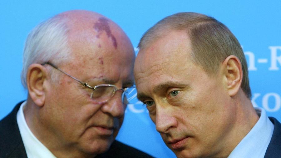 O Presidente russo Vladimir Putin (à direita) ouve o ex-presidente da URSS Mikhail Gorbachev - Christian Charisius/Foto de Arquivo/Reuters - 21.dez.2004