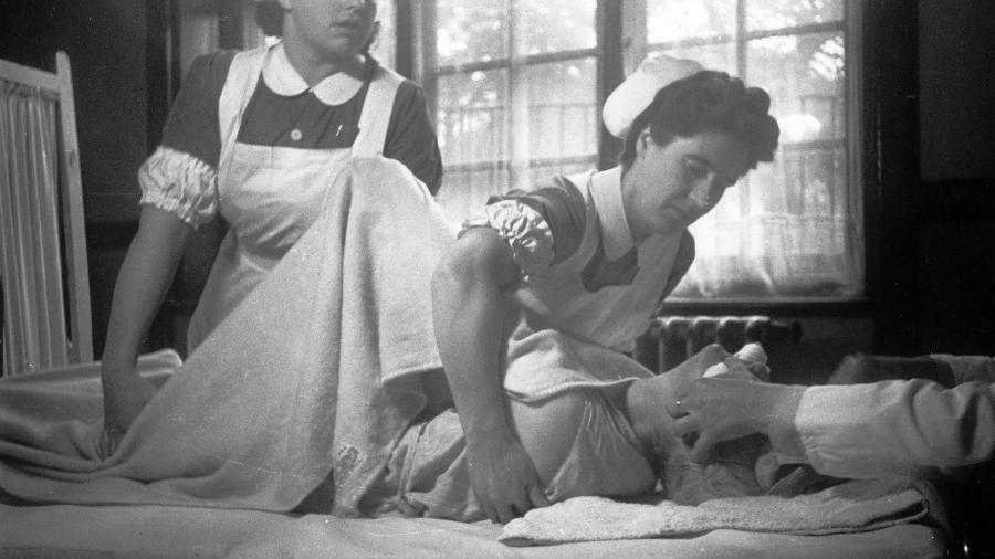 Enfermeiros atendem um paciente que recebe tratamento com eletrodo em hospital psiquiátrico, em imagem sem data - Kurt Hutton/Getty Images