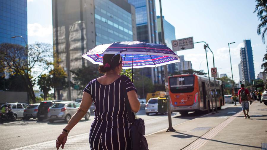 12.set.2019 - Pedestre usa sombrinha para se proteger do sol forte na Avenida Brigadeiro Faria Lima, na capital paulista - TIAGO QUEIROZ/ESTADÃO CONTEÚDO