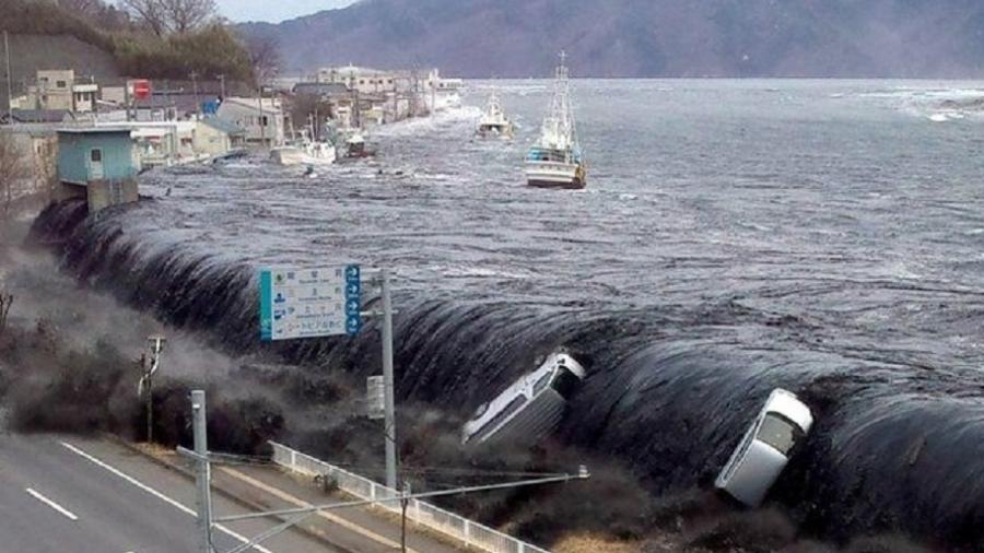 O mar superou barreiras e invadiu cidades, arrastando carros e barcos, como em Miyako - Jiji Press/AFP