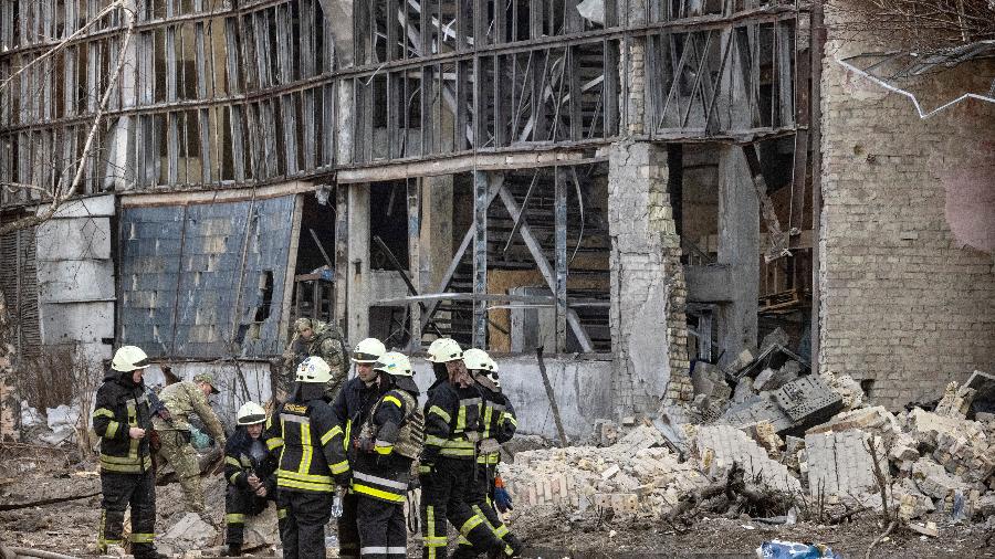 22.mar.22 - Bombeiros sentam-se em meio a escombros na área de um instituto de pesquisa, parte da Academia Nacional de Ciências da Ucrânia, após um ataque de drones que matou pelo menos um, no noroeste de Kiev - FADEL SENNA/AFP