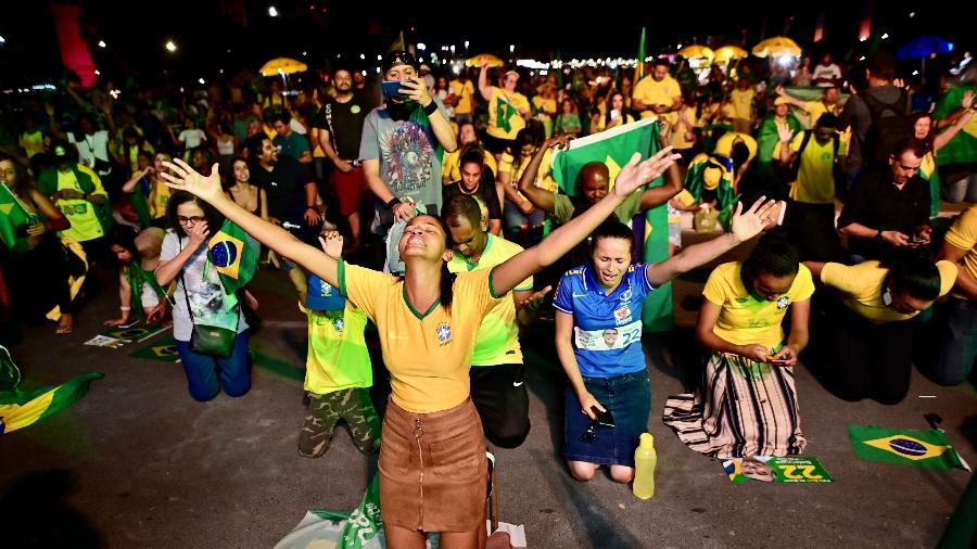 Apoiadores de Bolsonaro rezam durante a apuração dos votos para presidente na Esplanada dos Ministérios, em Brasilia - Ruy Baron/AFP