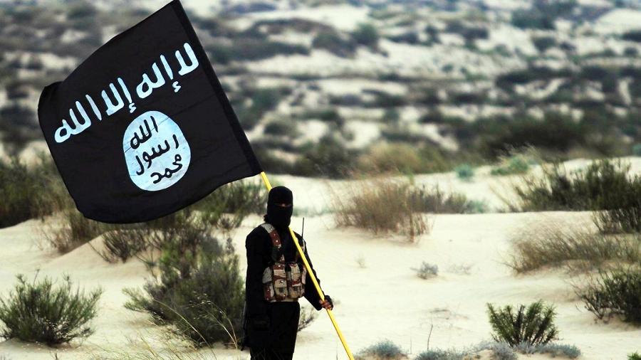 Integrante do Estado Islâmico com bandeira do grupo terrorista - Getty Images