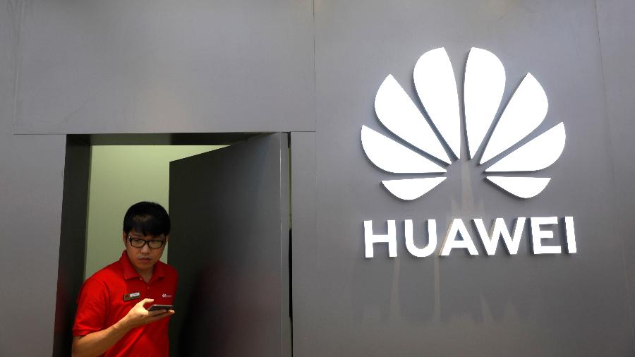 Funcionário sai de loja da Huawei em Bancoc, na Tailândia - Soe Zeya Tun/Reuters