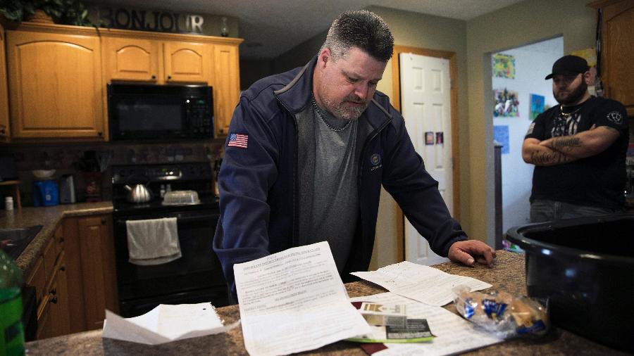 Rick Marsh dá uma olhada em documentos em sua casa em Warren, Ohio - Maddie McGarvey/The New York Times