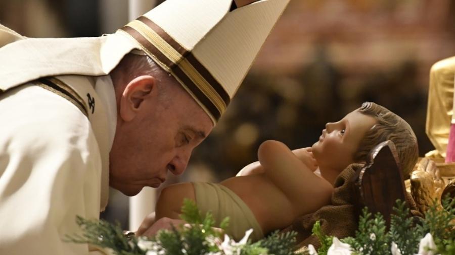Papa Francisco beija os pés de uma imagem do menino Jesus em celebração na basílica de São Pedro, no Vaticano - 24.dez.2020 - AFP