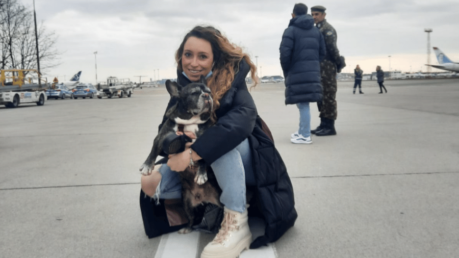 9.mar.2022 - A bióloga Vanessa Rodrigues Granovski e o cachorro Thor pouco antes de embarcar em voo da FAB para o Brasil - Arquivo pessoal