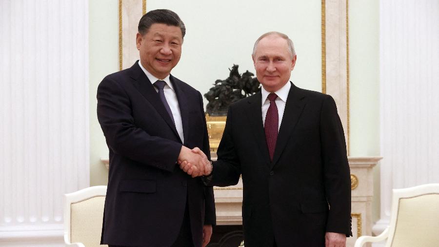 Xi disse que ambos estão de acordo com o "reforço da coordenação" e que ligações entre os dois países são "cruciais" na nova ordem mundial. - Sergei KARPUKHIN/SPUTNIK/AFP