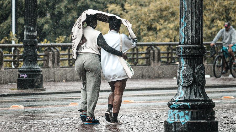 28.jan.2024 - Pedestres se protegem da chuva na região do Vale do Anhangabaú, centro de São Paulo