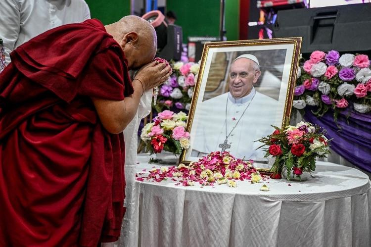 Um monge derrama pétalas de flores enquanto presta homenagem diante de um retrato do Papa Francisco em Nova Déli Um monge derrama pétalas de flores enquanto presta homenagem diante de um retrato do Papa Francisco em Nova Déli
