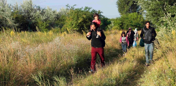 Imigrantes afegãos caminham após cruzar a fronteira da Sérvia com a Hungria, em junho - Laszlo Balogh/Reuters