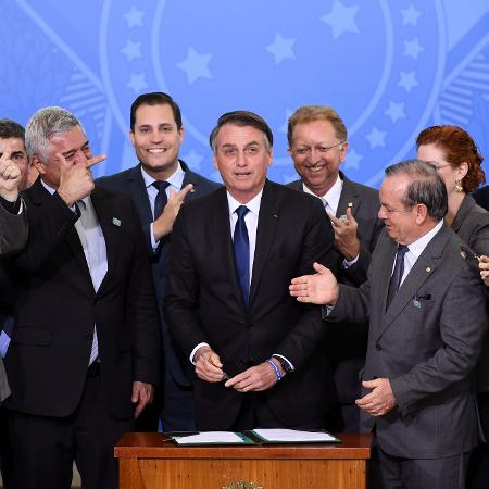 7.mai.2019 - Presidente Jair Bolsonaro cercado por parlamentares durante cerimônia de assinatura do decreto - Evaristo Sa/AFP