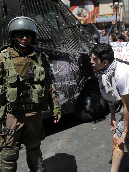 21.out.2019 - Manifestante mostra ferimento para militar em Valparaíso, no Chile - Javier Torres / AFP