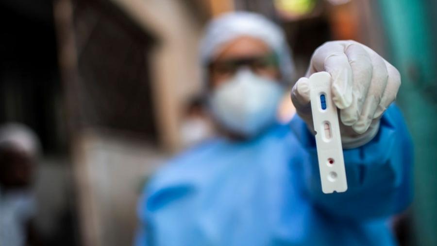 Agente de saúde segura teste com resultado positivo para o novo coronavírus durante testagem na favela da Mangueira, no Rio de Janeiro - Bruna Prado/Getty Images