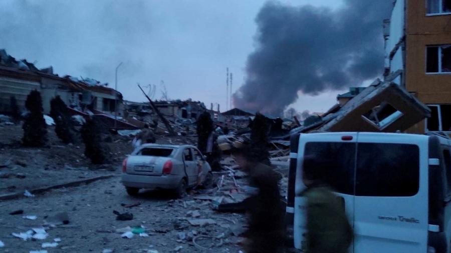 13.mar.2022 - Fumaça sobe em meio a prédios e veículos danificados após um ataque à base militar de Yavoriv - @BackAndAlive/via REUTERS