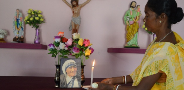 Monica Besra coloca uma vela em um altar para a Madre Teresa em sua casa em Nakur, Índia - Diptendu/ AFP