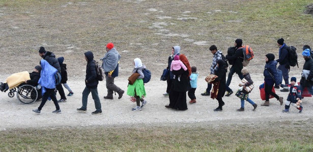 Migrantes caminham ao posto da polícia federal alemã após passar pela fronteira entre Áustria e Alemanha - CHRISTOF STACHE/AFP