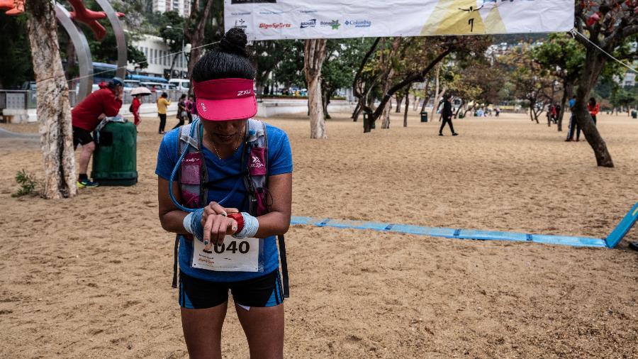 Jaybie Pagirigan, uma empregada doméstica filipina, checa seu tempo após uma corrida em Hong Kong - Xyza Cruz Bacani/The New York Times