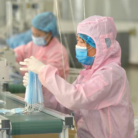 Coronavírus: Linha de produção de máscaras protetoras na China - Xinhua/Liu Xiao