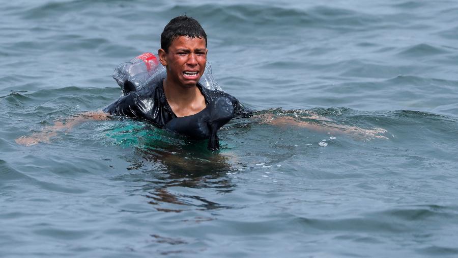 Imagem do jovem Aschraf Sabir , em 19 de maio, nadando com garrafas de plástico amarradas ao corpo para não se afogar em direção a Ceuta, na fronteira entre o Marrocos e a Espanha - REUTERS/Jon Nazca
