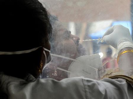 9.jun.2021 - Trabalhadora da saúde coleta amostra nasal de paciente para teste de covid-19 em Hyderabad, na Índia - Noah Seelam/AFP