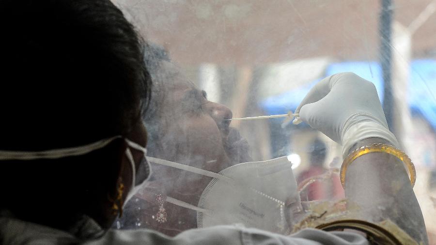 9.jun.2021 - Trabalhadora da saúde coleta amostra nasal de paciente para teste de covid-19 em Hyderabad, na Índia - Noah Seelam/AFP