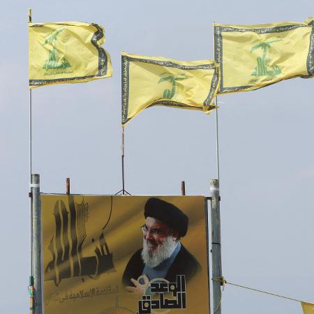 Bandeiras do Hezbollah retratam o líder do grupo, Hassan Nasrallah