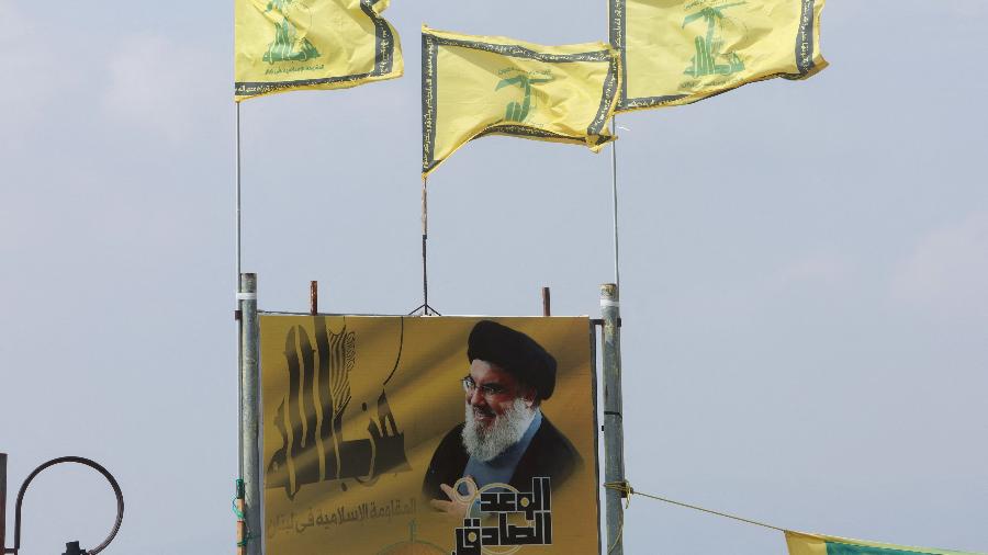 Bandeiras do Hezbollah retratam o líder do grupo, Hassan Nasrallah