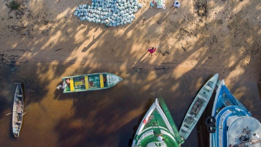 Para levar kits de limpeza às comunidades no Rio Arapiuns, é preciso fazer a entrega de barco - Leonardo Milano/Projeto Saúde e Alegria